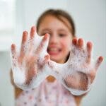 Little girl washing hands with water and soap in bathroom. Hands